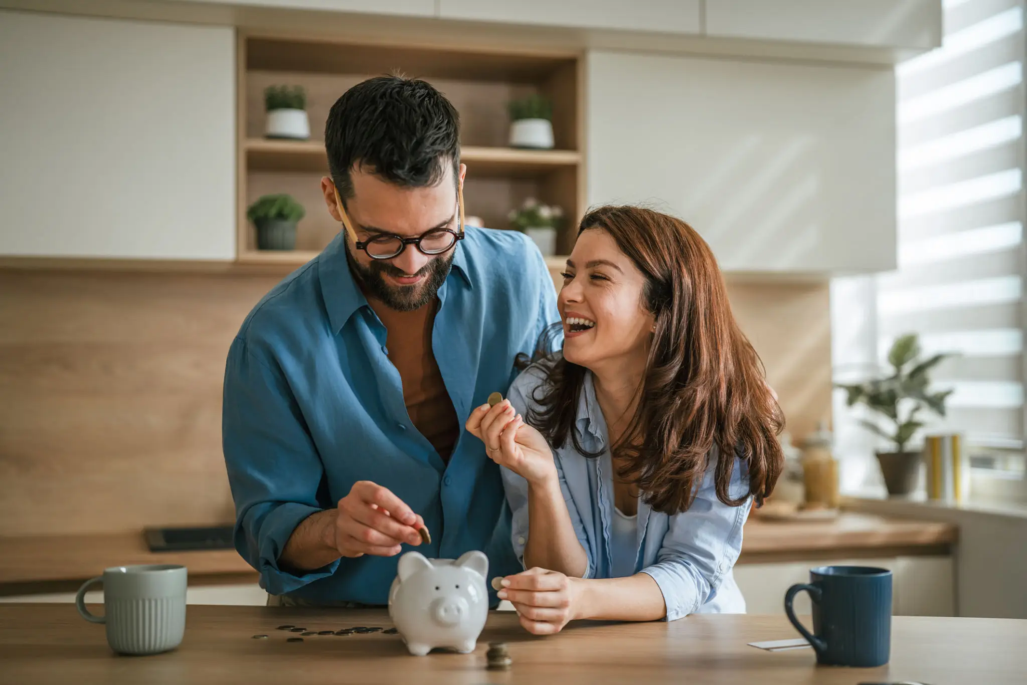 Happy couple saving money in piggy bank