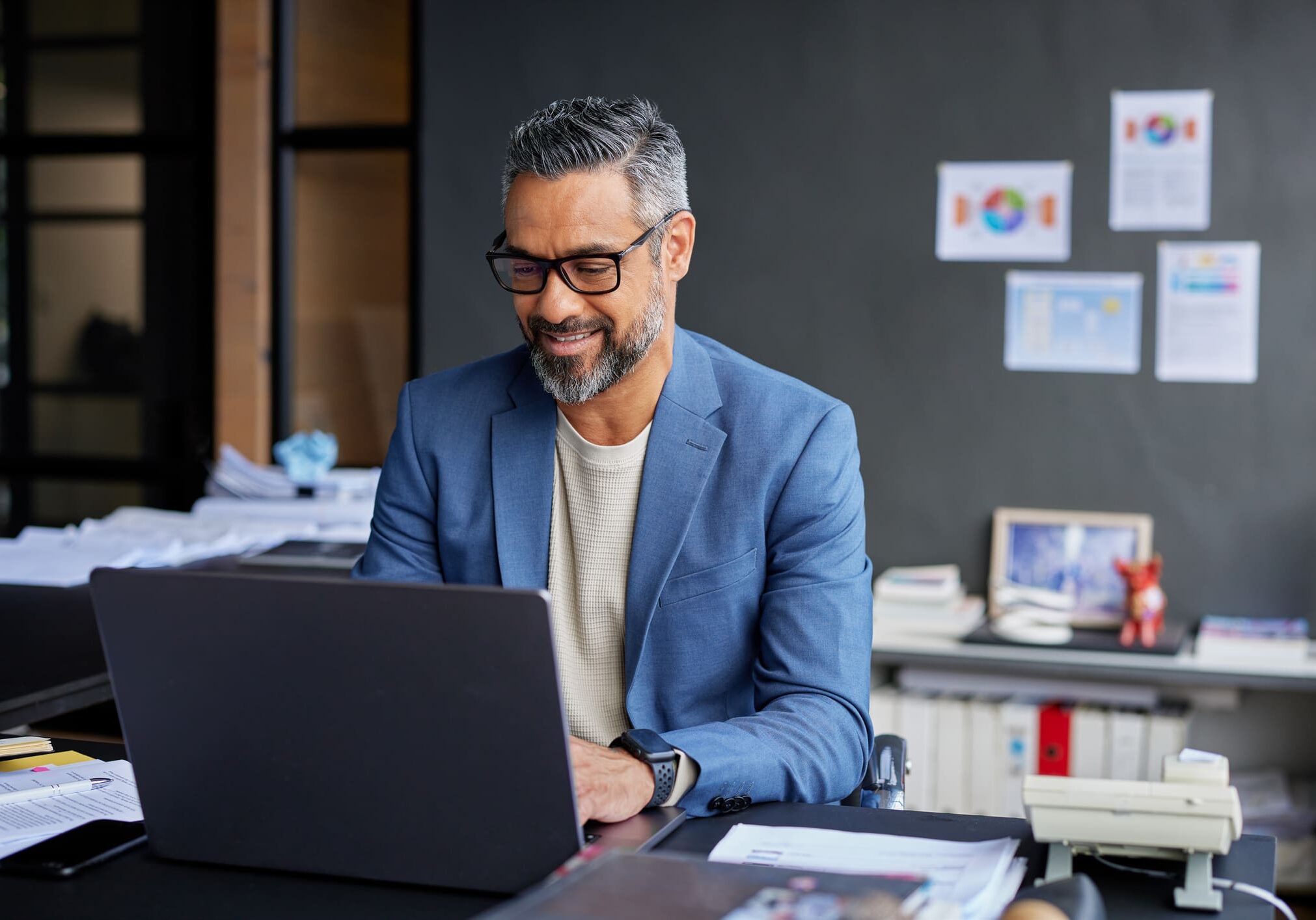 Business owner reviewing a budgeting spreadsheet on a laptop.